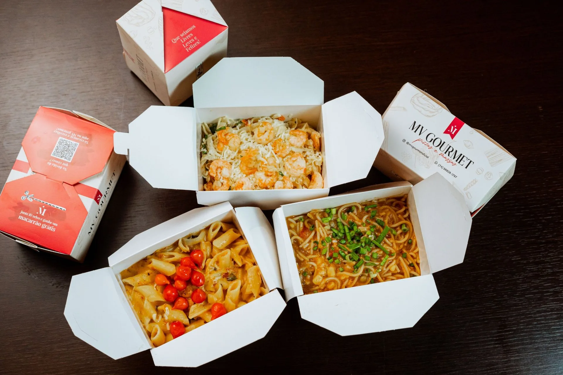 Caixas de comida preparada e embalagens para takeaway sobre uma mesa.