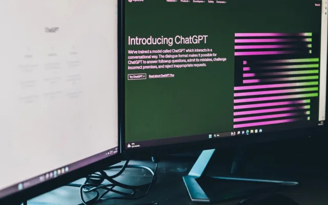 Computador num ambiente de trabalho com uma ferramenta de inteligência artificial aberta no ecrã.
