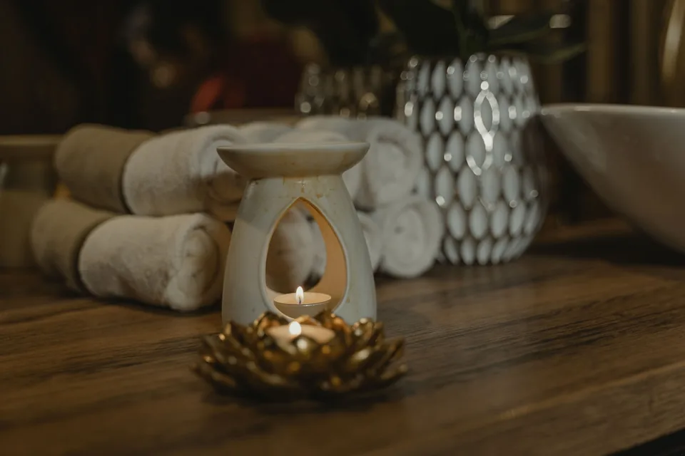 Ambiente de bem-estar com toalhas, vela e elementos de aromaterapia