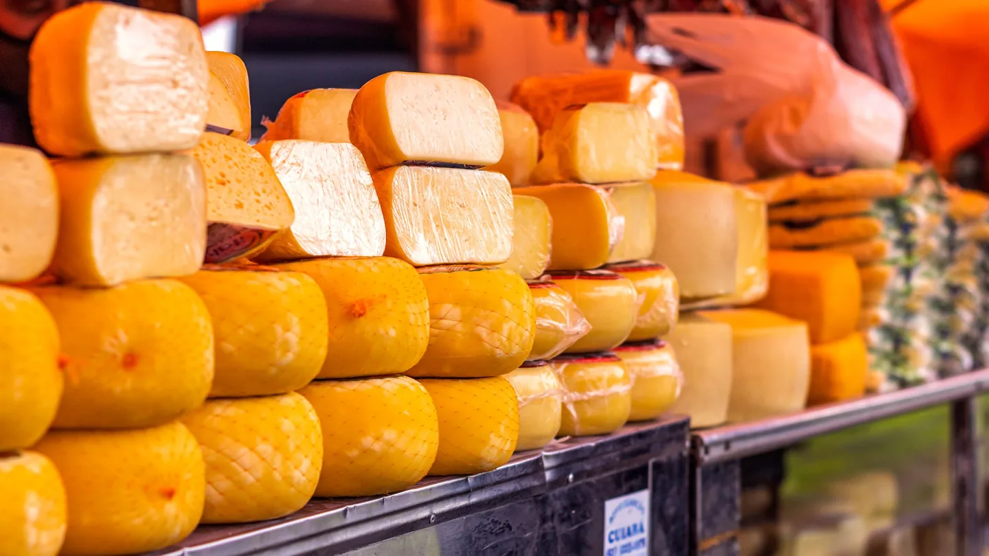Queijos regionais apresentados num mercado, representando uma loja online de produtos com origem