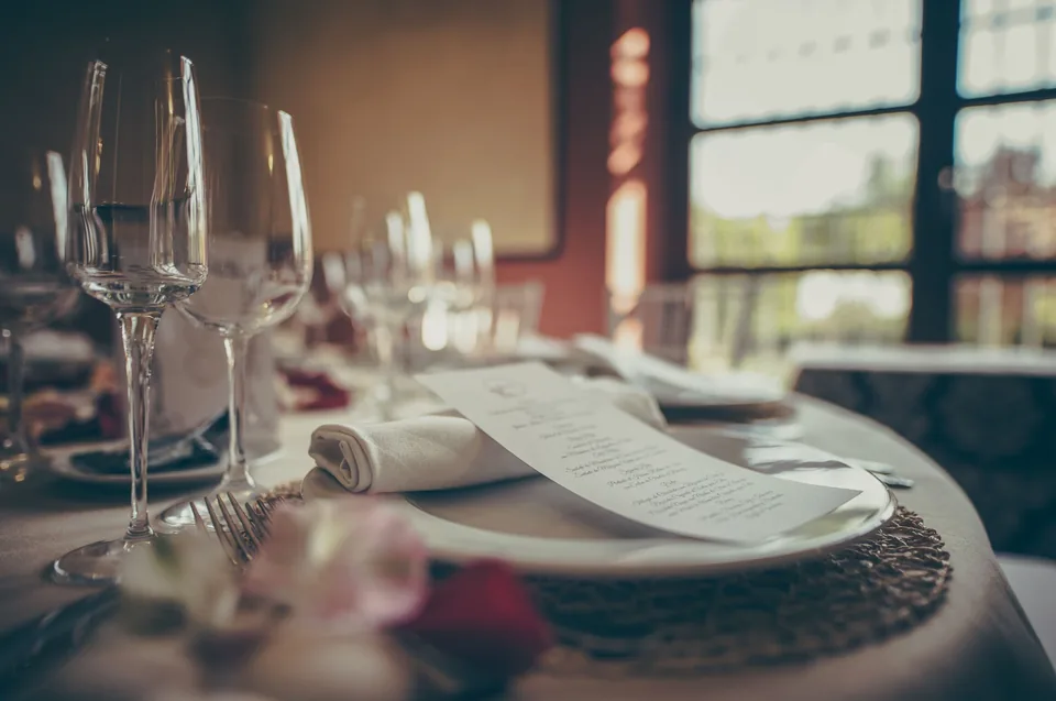 Mesa de restaurante com menu e copos preparados, representando informação clara antes da reserva